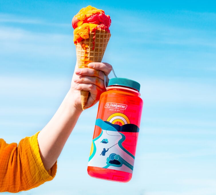 A hand holding an ice cream cone and a32oz Retro Nalgene bottle